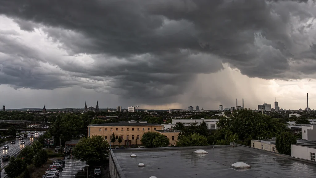 Dramatische Gewitterfront über einer NRW-Stadt als Symbolbild zur DWD-Warnlage.