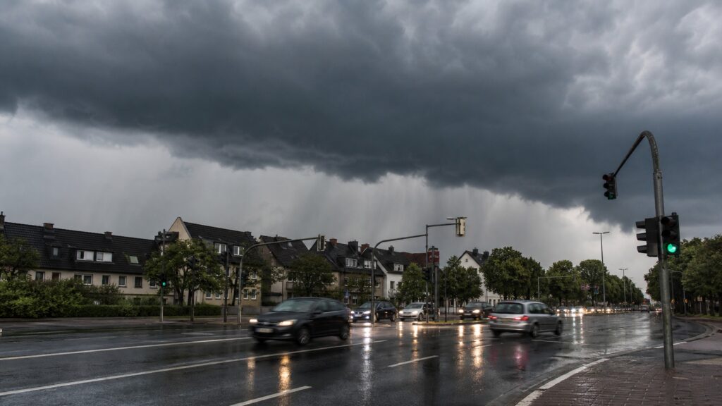 Dunkle Gewitterwolken ziehen über eine Stadt in Nordrhein-Westfalen.