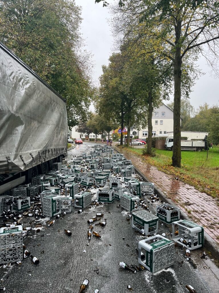Zahlreiche Getränkekisten und Glasscherben liegen neben einem Lastwagen auf der B252 bei Brakel-Siddessen.